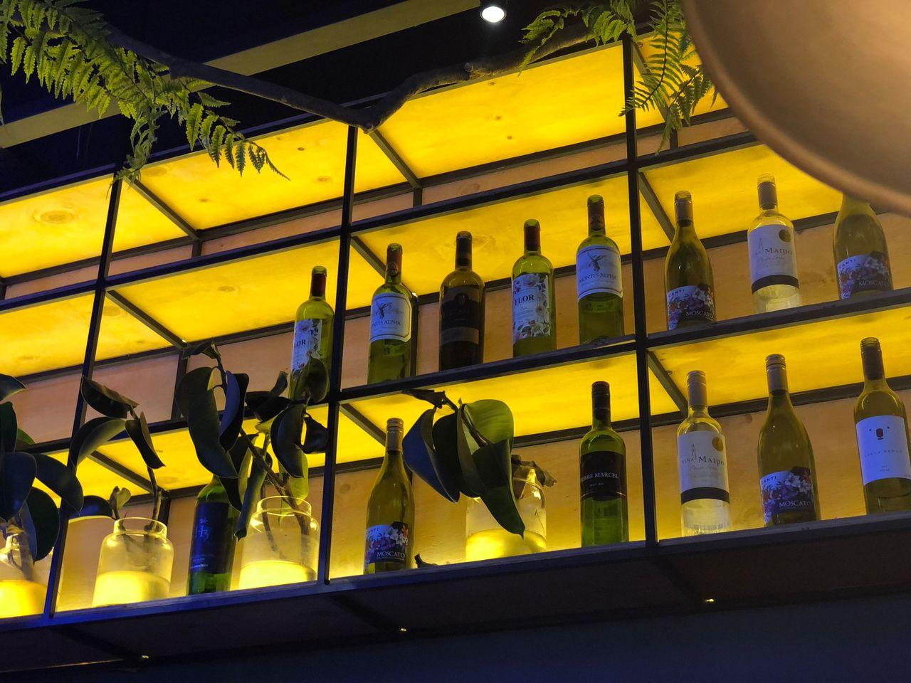 오늘 와인한잔 牆上的裝飾瓶和酒架，展示多樣性的酒款。